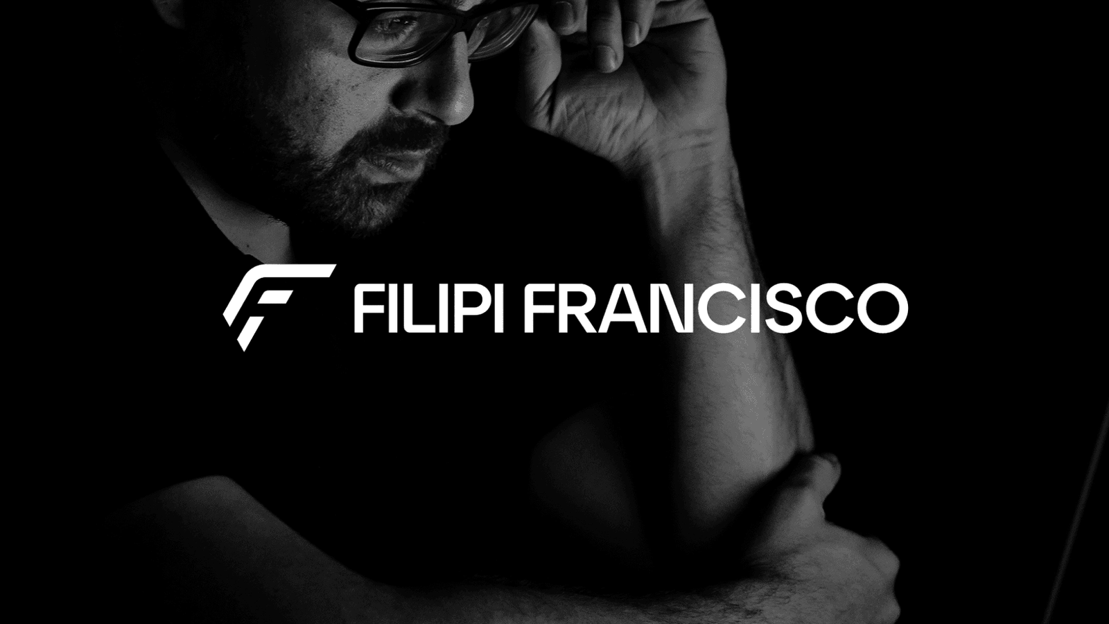 A black and white portrait of Filipi Francisco, hand to head, with the Filipi Francisco logo across the image