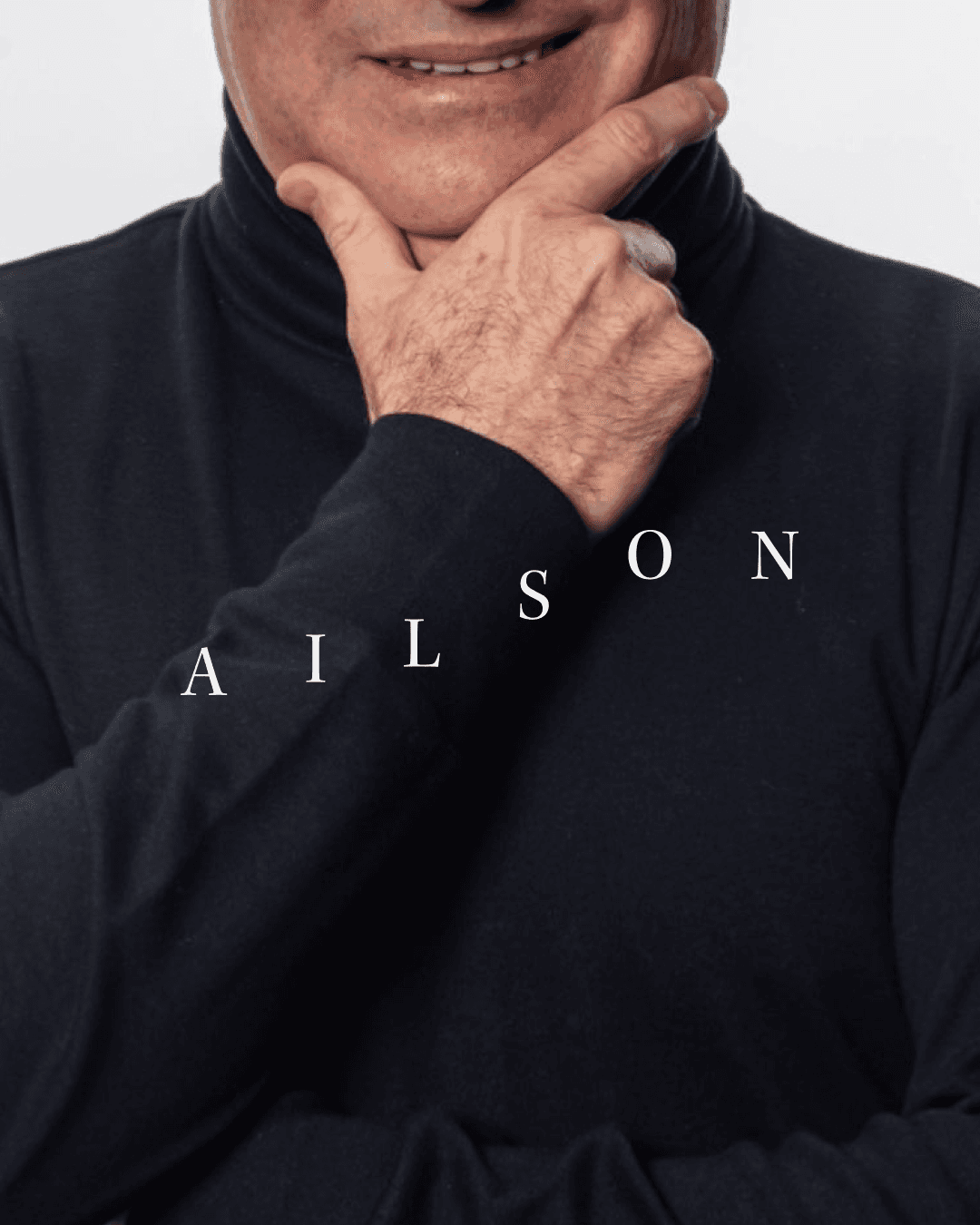 A photograph of Ailson de Moraes in a black roll-neck, hand to chin, with the AILSON wordmark across the image