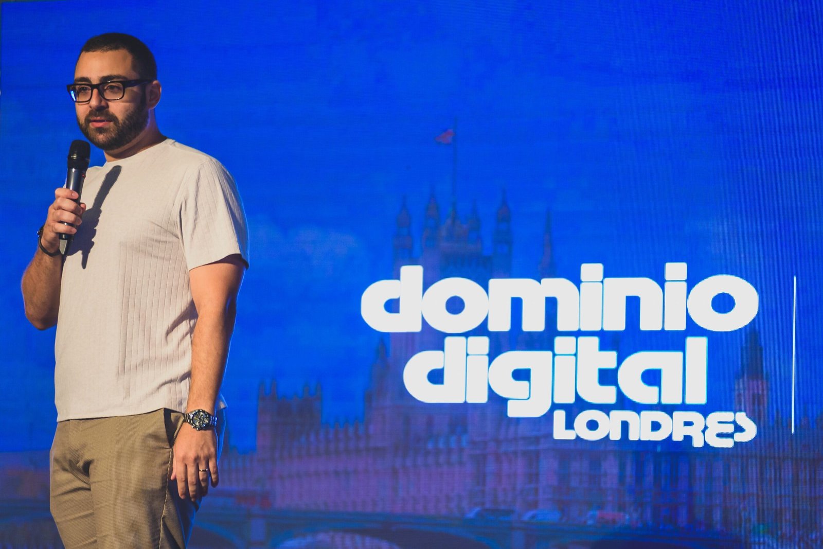 A speaker in front of a screen reading Dominio Digital Londres, set against the Houses of Parliament